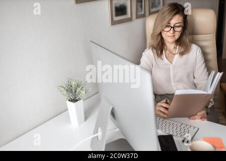 Schöne Geschäftsfrau, die zu Hause an Computern arbeitet Stockfoto