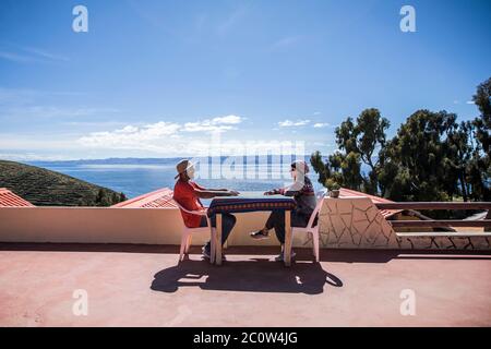 Pärchen sitzt auf einem Tisch vor einem schönen See mit blauem Himmel Stockfoto