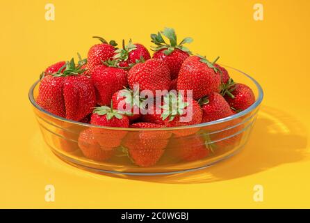 Frische reife und leckere Erdbeeren in einer Glasschüssel auf gelbem Hintergrund Stockfoto