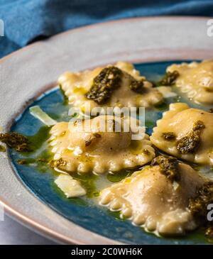 Gedämpfte Ravioli gefüllt mit Kürbis mit Pesto-Sauce. Stockfoto