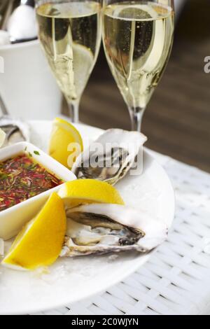 Frische Austern Schale mit Zitrone und Gläser Champagner. Draufsicht Stockfoto