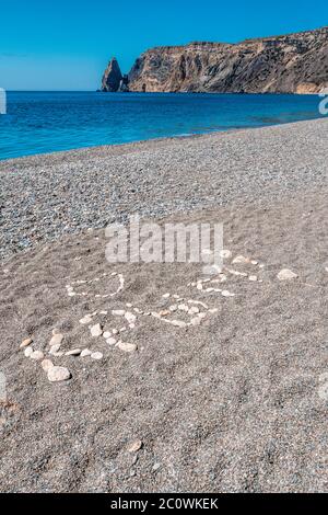 Die Inschrift auf russisch ist aus den grauen glatten Kieselsteinen auf dem Jaspisstrand, dem Kap Fiolent in Balaklava, der Stadt Sewastopol angelegt. Übersetzung: Krim Stockfoto