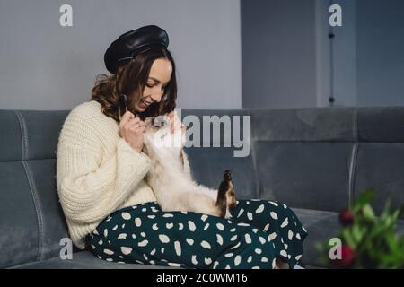 Schöne Frau spielt mit Siam Katze zu Hause. Freundschaft zwischen Mensch und Tier Stockfoto