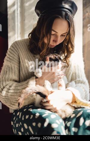 Schöne Frau spielt mit Siam Katze zu Hause. Freundschaft zwischen Mensch und Tier Stockfoto