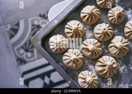 Haufen von hausgemachten rohen khinkali leckere georgische Knödel auf heimischen Küchentisch Stockfoto