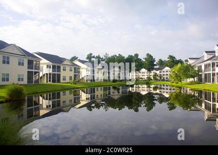 Südliche Wohngegend. Hintergrund mit einem modernen Viertel mit Gebäuden rund um den Teich. Häuser und Bäume spiegeln sich in der ruhigen wa Stockfoto