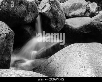 Verschwommener Fluss Stream Detail der wilden felsigen Berg Fluss. Seidiger Effekt. Effekt der Bewegungswiedergabe. Langsame Verschlusszeit. Langzeitbelichtung. . Schwarzweiß-Bild. Stockfoto