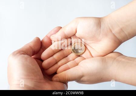 Nahaufnahme von Vater und Kind Händen halten Euro-Münzen. Familie, Kinder, Geld, Investitionen, Menschen Konzept Stockfoto