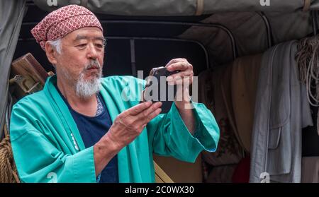 Alter Japaner mit Smartphone in Shibuya, Tokio, Japan Stockfoto