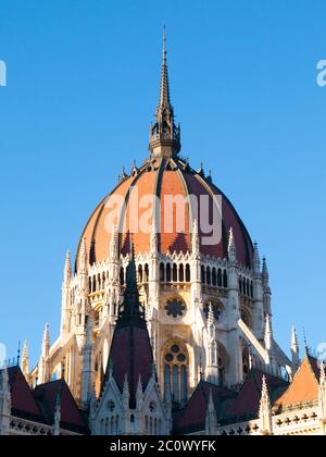 Detailansicht des historischen Gebäudes des ungarischen Parlaments, aka Orszaghaz, mit typischer zentraler Kuppel auf klarem blauen Himmel Hintergrund. Budapest, Ungarn, Europa. Es ist ein bemerkenswertes Wahrzeichen und Sitz der Nationalversammlung von Ungarn. UNESCO-Weltkulturerbe. Stockfoto
