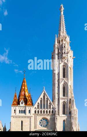 Römisch-katholische Matthias-Kirche und Heilige Dreifaltigkeit Pest Säule in Fisherman's Bastion in Buda Castle District, Budapest, Ungarn, Europa. Sonniger Tagesfoto mit klarem blauen Himmel. Stockfoto