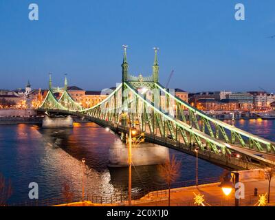 Beleuchtete Freiheitsbrücke und Donau bei Nacht. Budapest, Ungarn. Stockfoto