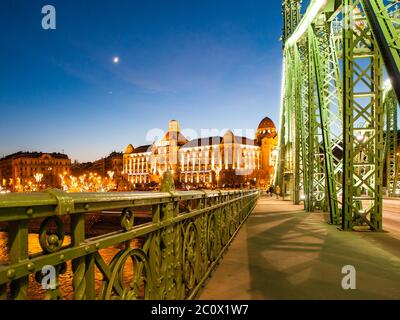 Nachtaufnahme. Jugendstil historisches Gebäude von Gellert Spa am Ufer der Donau in Budapest, Hauptstadt von Ungarn, Europa. Abendansicht von der Liberty Bridge. Stockfoto