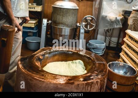 Mann mit einem großen Hammer Vorbereitung traditionelle japanische klebrige rechten Snack Mochi Stockfoto