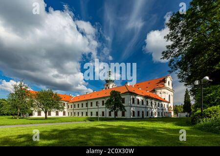 Brevnov, Prag / Tschechien - Juni 11 2020: Blick auf das erste männliche Kloster in Böhmen, das an einem sonnigen Sommertag in einem Park mit grünen Bäumen steht. Stockfoto