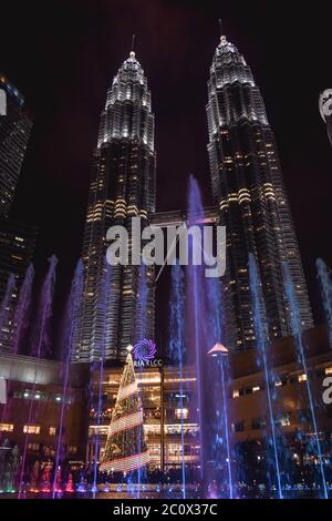 Während der Weihnachtszeit plätschert ein Springbrunnen vor den Petronas Twin Towers im KLCC Park in Kuala Lumpur Stockfoto