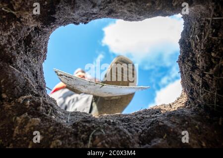 Fuß graben eine Erde im Garten mit einem alten Spaten, aus nächster Nähe. Stockfoto