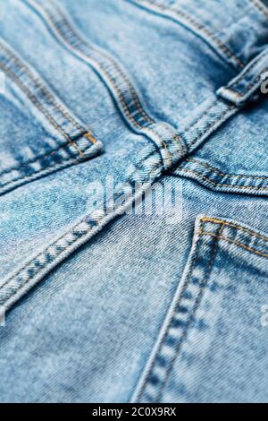 Nahaufnahme aus Denim-blauer Qualität mit Taschen und gelben Nähten. Modische Jeans. Vorderansicht. Stockfoto