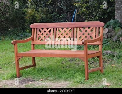 Verzierte Parkbank auf dem Gras vor einem üppigen Wald Stockfoto