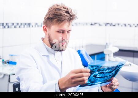 Arzt in Uniform hält Röntgenaufnahme Stockfoto