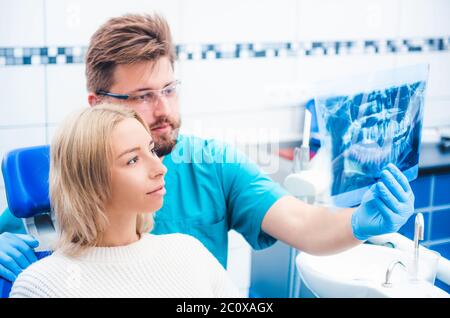 Arzt zeigt dem Patienten einen Röntgenüberblick Stockfoto