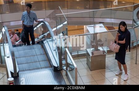 Passagiere, die mit der Rolltreppe am Internationalen Flughafen Haneda, Tokio, Japan fahren Stockfoto