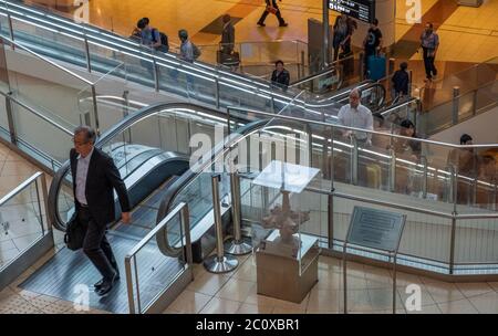 Passagiere, die mit der Rolltreppe am Internationalen Flughafen Haneda, Tokio, Japan fahren Stockfoto