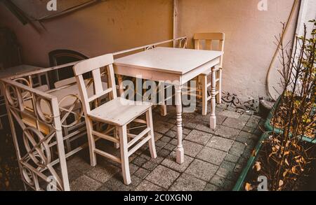 Kleiner weißer Holztisch und zwei Holzstühle im schönen Garten. Stockfoto