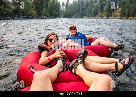 1. Person Standpunkt von zwei Frauen und einem Mann, der den Wenatchee River, Washington, USA, hinuntertubelt. Stockfoto