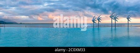 Auf der Cairns Esplanade, einer öffentlichen Badelagune am Rande des Great Barrier Reef in Queensland, Australien, brauen bei Sonnenaufgang Sturmwolken. Stockfoto