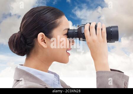 Zusammengesetztes Bild der Seitenansicht eine Geschäftsfrau auf der Suche durch ein Fernglas Stockfoto