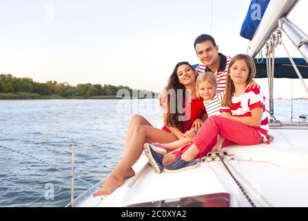 Schöne glückliche Familie mit zwei Töchtern, die tolle Zeit auf der Yacht haben Stockfoto