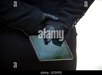 Bukarest, Rumänien - 01. Juni 2020: Eine Kellnerin mit schwarzen Handschuhen hält während einer Pressekonferenz von Hotel und Restaurant ein Tablet in der Hand Stockfoto