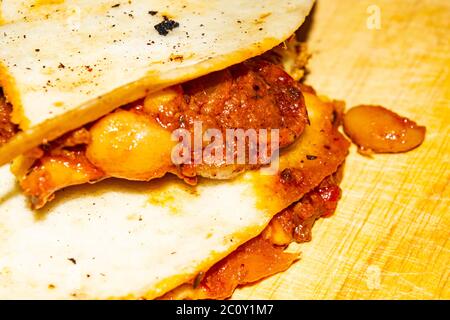 Quesadilla mit Hackfleisch, Wurst, roten Bohnen, Mais, Zwiebeln und Tomatensauce. Ein traditionelles mexikanisches Essen. Nahaufnahme Stockfoto