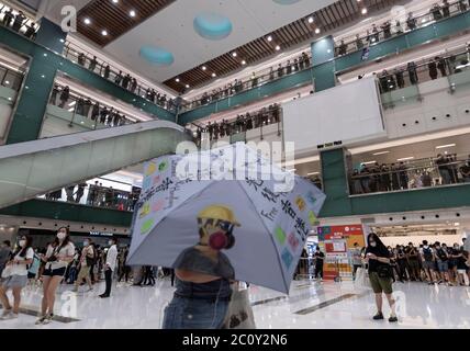 Ein Protestler hält während der Demonstration einen Regenschirm.Tausende von Hongkongern sangen am 12. Juni Protesthymne und skandierten Parolen in der Stadt, als sie den einjährigen Jahrestag der großen Auseinandersetzungen zwischen Polizei und prodemokratischen Demonstranten anprangern. Stockfoto