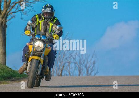 Ein Blick auf einen Mann, der auf offener Straße ein Motorrad fährt Stockfoto