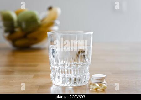 Nahaufnahme Glas mit Wasser und funkelnde Pille. Magnesium Anti-Stress, Schmerzmittel oder Orangengetränk Stockfoto