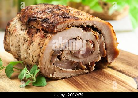 Schweinebraten roll gefüllt mit anderen Fleisch- und getrockneten Tomaten auf Schneidebrett Stockfoto