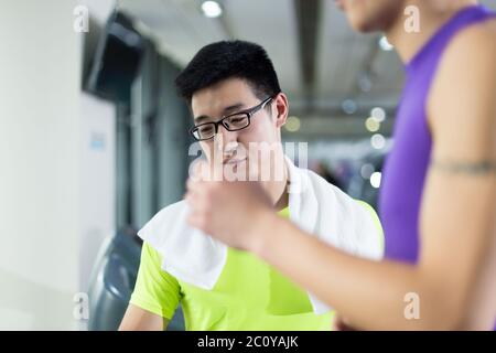 Jungen asiatischen Menschen arbeiten in modernen Fitnessraum Stockfoto