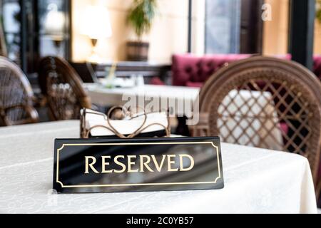 Ein Tag der Reservierung, der auf dem Tisch platziert wird. Reserviertes Logo in einem Restaurant oder Sommerterrasse des Cafés. Stockfoto