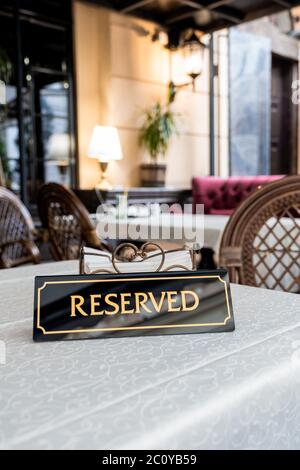 Ein Tag der Reservierung, der auf dem Tisch platziert wird. Reserviertes Logo in einem Restaurant oder Sommerterrasse des Cafés. Stockfoto