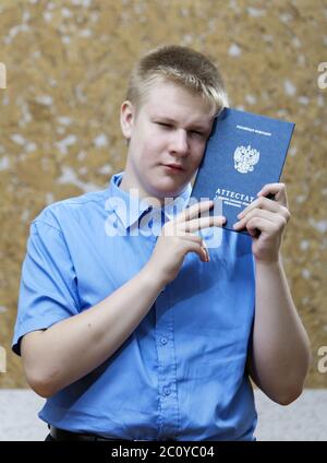 Schuljunge mit dem Zertifikat über den Abschluss der Ausbildung in der Schule , aufgeregt von Abschied mit sch Stockfoto