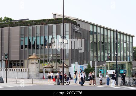 Menschen warten darauf, die Straße vor dem alten und neuen Bahnhof Harajuku zu überqueren. Während des Coronavirus-Ausbruchs tragen Menschen Gesichtsmasken. Stockfoto