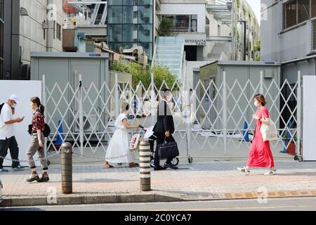 Eine Straße in Tokyos Shibuya-Gegend. Im Hintergrund ist der im Bau befindliche Miyashita Park. Menschen tragen Gesichtsmasken während des Coronavirus-Ausbruchs. Stockfoto