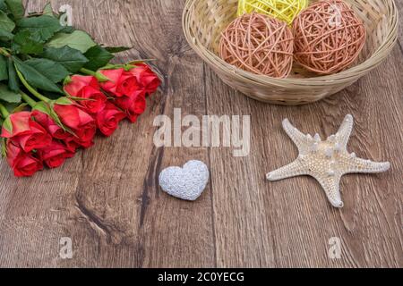 Seesterne, Herzen und Rosen auf einem hölzernen Hintergrund Stockfoto