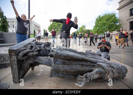 10. Juni 2020: Nachdem ein Mann von indianischen Aktivisten niedergerissen wurde, tritt er die Statue von Christoph Kolumbus, während sie am 10. Juni 2020 mit dem Gesicht nach unten auf dem Boden im Minnesota State Capitol in Saint Paul liegt. (Bild: © Chris JuhnZUMA Wire) Stockfoto