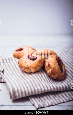 Hausgemachte Erdbeermuffins auf Holztablett mit weiß karierter Serviette unterordentlich. Stockfoto