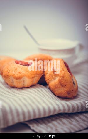 Leckere Muffin Kuchen. Hausgemachte Buttercreme-Cupcakes mit Erdbeeren auf weißem Holztisch. Stockfoto