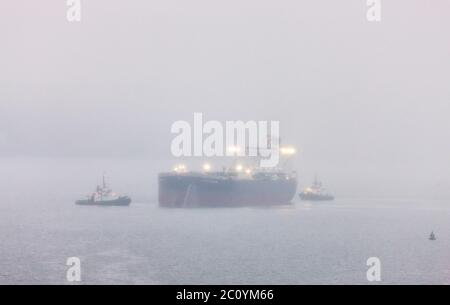 Whitegate, Cork, Irland. Juni 2020. Öltanker British Reason fährt an einem nebligen Morgen, unterstützt von den Schleppern DSG Titan und Alex, nachdem sie ihre Ladung von West Texas Intermediate Rohöl in der Whitegate Ölraffinerie in Co. Cork, Irland, entsorgt hatten. - Credit; David Creedon / Alamy Live News Stockfoto