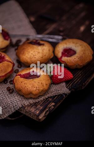 Erdbeer Schokolade Cupcakes Muffins auf alten Holzständer auf Beton grauen Hintergrund. Stockfoto
